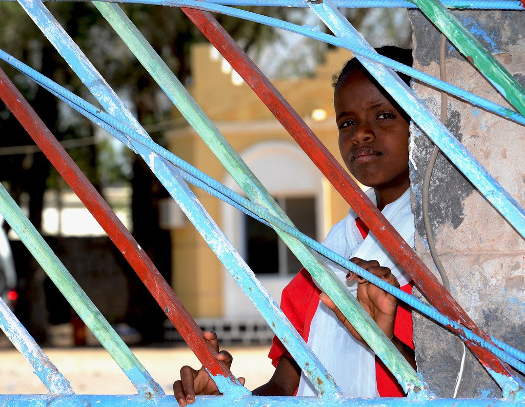 Jeune fille devant le portail coloré d'un centre de santé