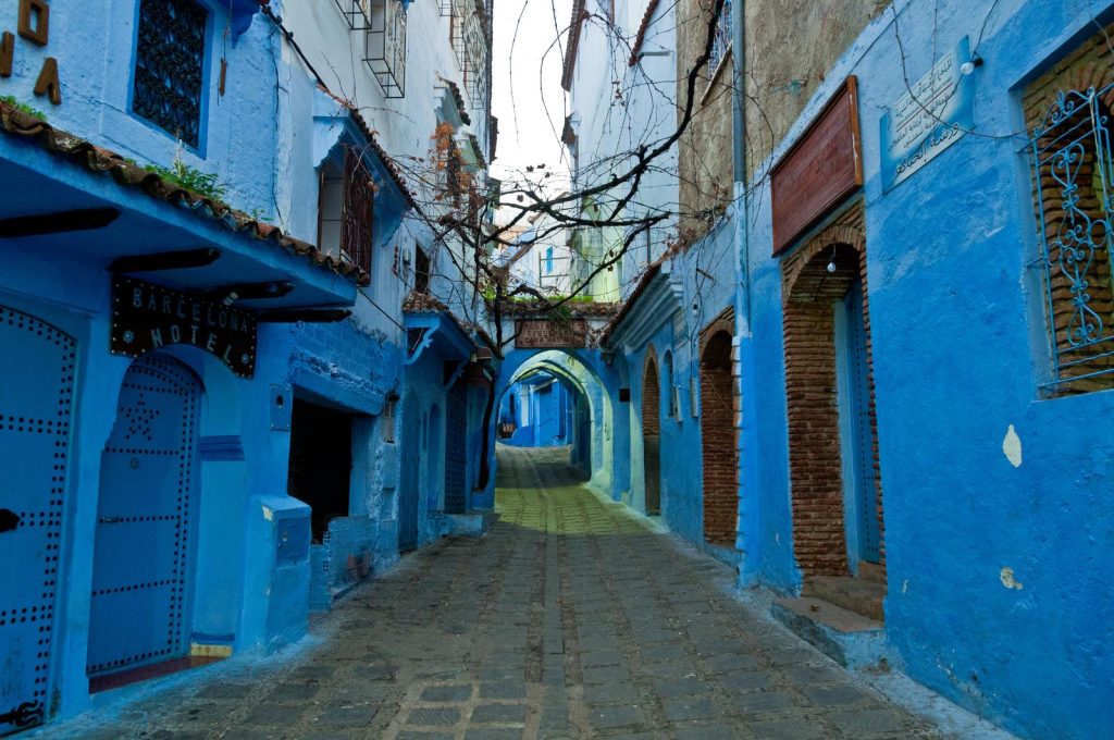 Ruelle bleue avec arche et enseigne d'hôtel dans la médina de Chefchaouen