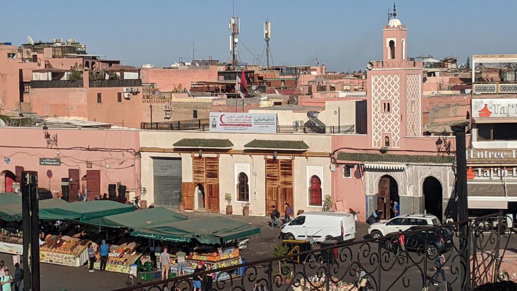Place Jemaa el-Fna à Marrakech en journée avec échoppes et mosquée