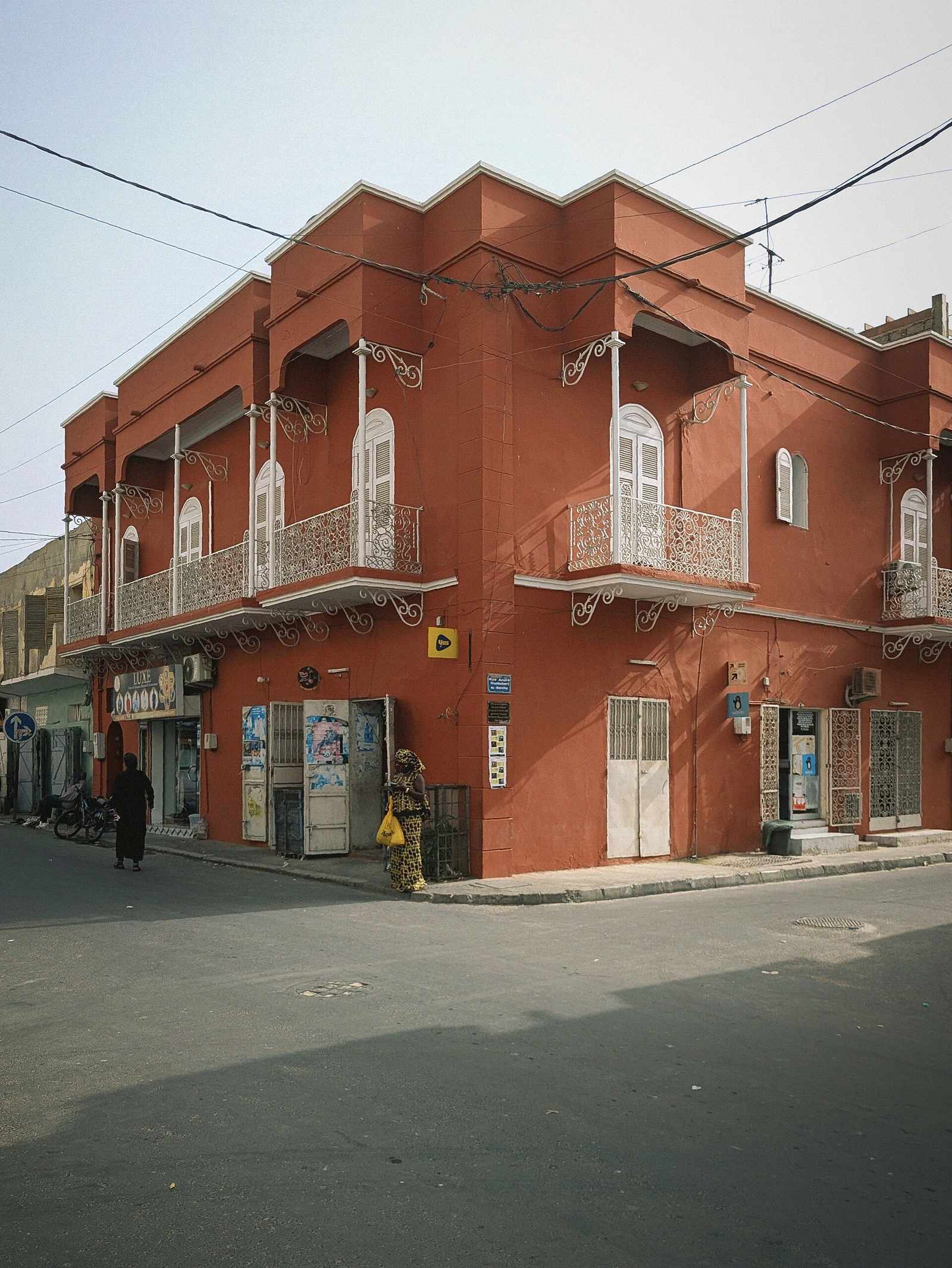 Façade ocre rouge à balcons en fer forgé typique de l'architecture coloniale de Saint-Louis du Sénégal