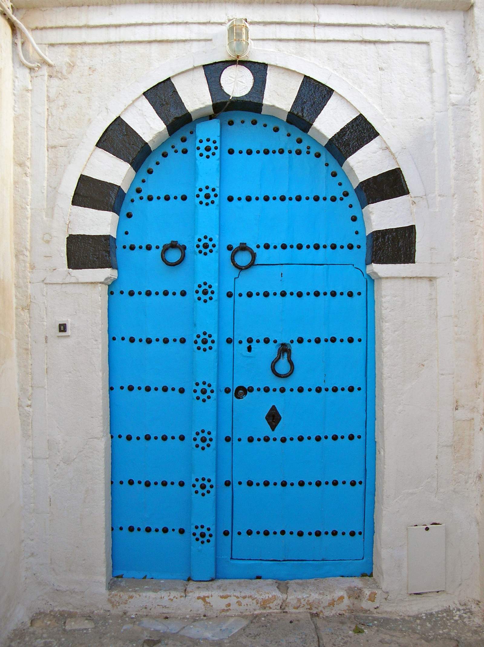 Porte bleue cloutée typique du village de Sidi Bou Saïd, en Tunisie